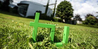 TU logo In the foreground one can see the green TU logo on the grass and in the background there is the Mathetower.